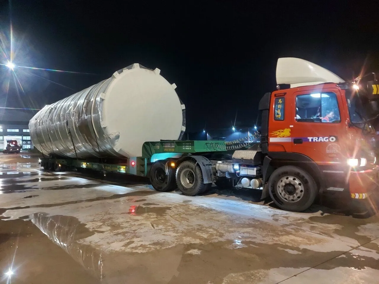 Xe đầu kéo vận chuyển bồn trụ công nghiệp cỡ lớn vào ban đêm