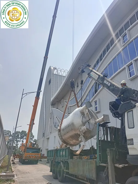 Cẩu nâng bồn inox dạng trụ trên thùng xe, căn chỉnh hướng tải trước khi hạ xuống