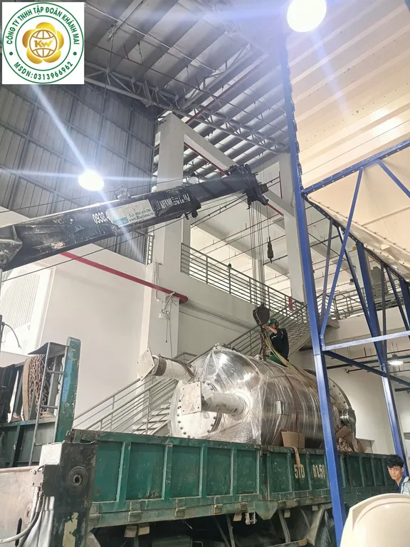Hạ thiết bị inox lên thùng xe, dùng dây dắt tải để hạn chế xoay và lắc
